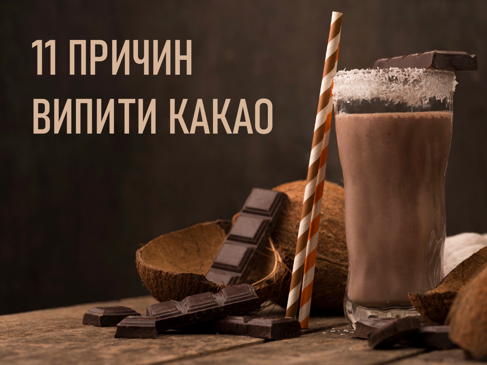 На зображенні склянка наповнена какао, поруч з нею шматки шоколаду і половина розколотого кокосу у верхній частині зображення підпис -11 причин випити какао